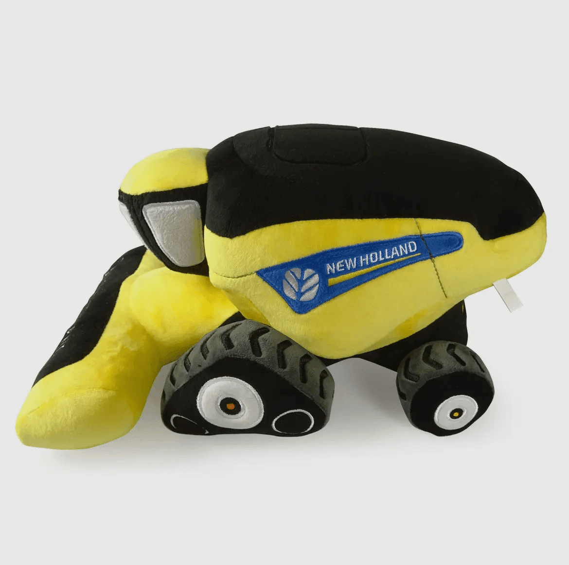 Soft plush combine harvester toy in yellow and black with New Holland logo, celebrating rural heritage for American Farm Company's agricultural lifestyle collection.