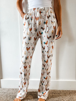A woman in Chicken Adult Pajama Pants standing in front of a pristine white wall.