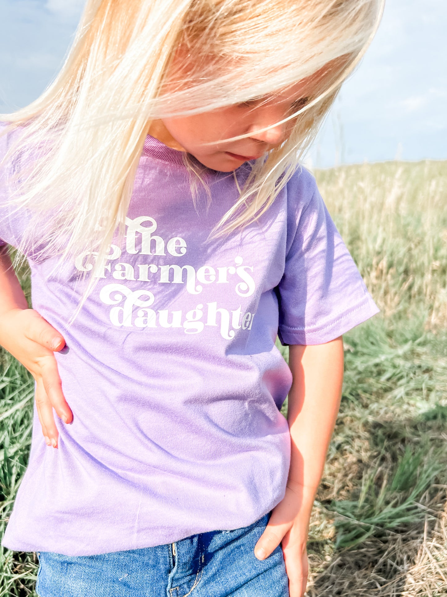 A kid in the field wearing The Farmers Daughter Youth and Toddler Onesies up close