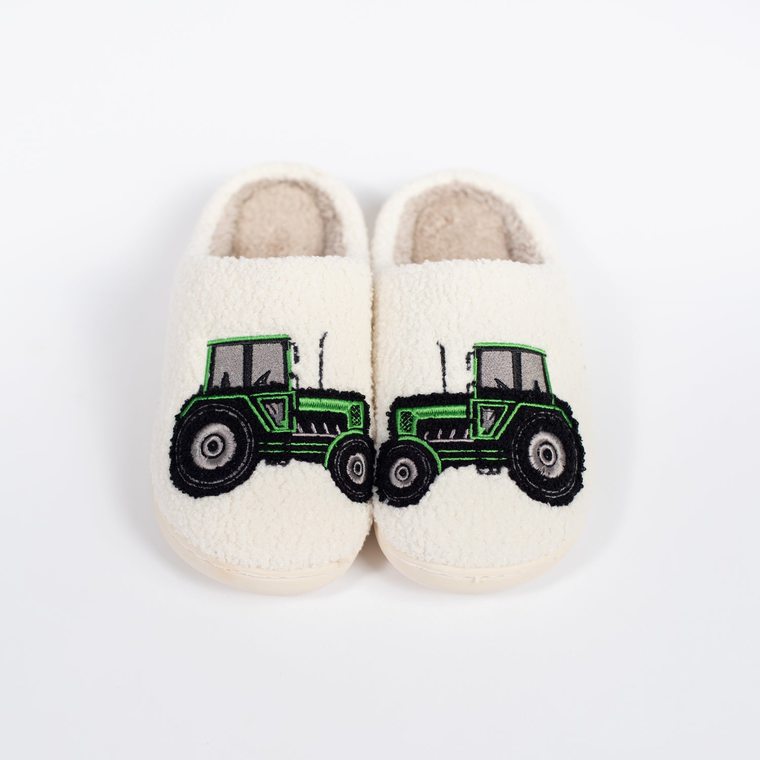 Kids’ cream sherpa slippers with bold green tractor embroidery, cozy rural heritage apparel by American Farm Company