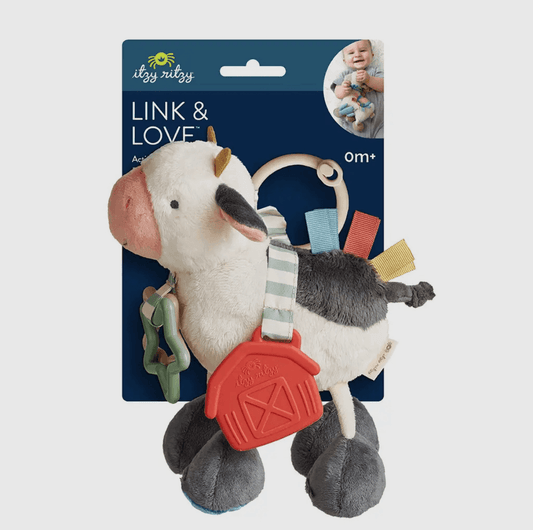 Plush cow activity toy with heritage-inspired barn teether, soft textures, and farmhouse charm for rural family lifestyle.