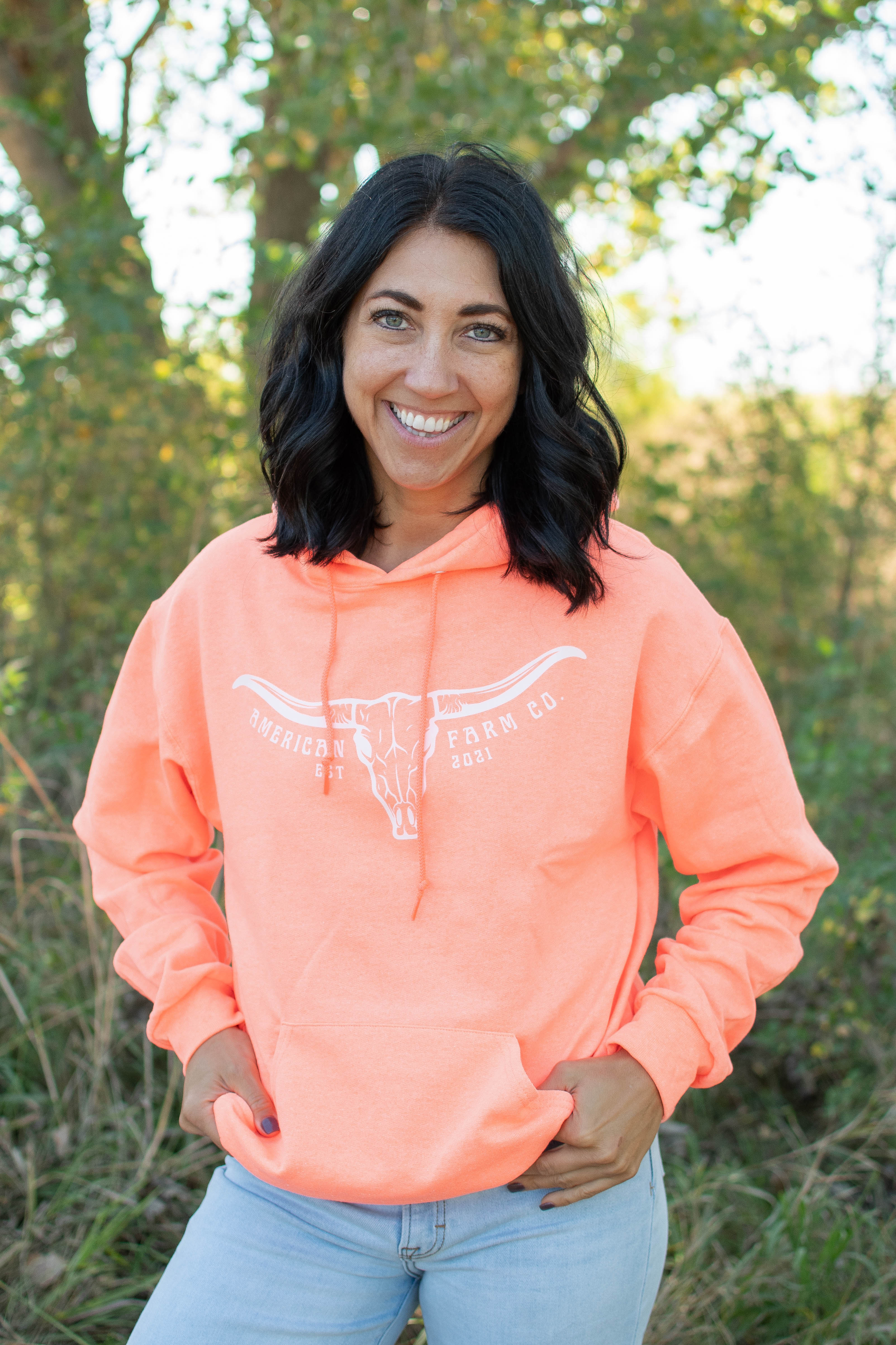 Coral relaxed fit hoodie with white longhorn skull graphic and American Farm Co. heritage branding, ideal rural lifestyle apparel