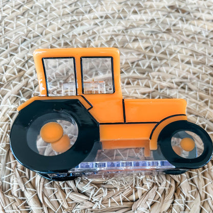 Photograph displaying a side view of an orange tractor claw clip.