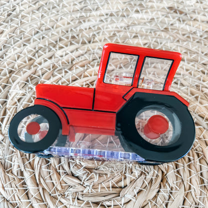 A photo showcasing the side view of a  Red  Tractor Hair Clip