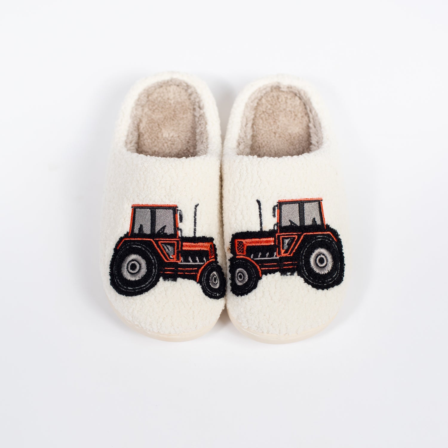 Cream sherpa kids' slippers with bold red tractor embroidery, cozy rural heritage footwear by American Farm Company
