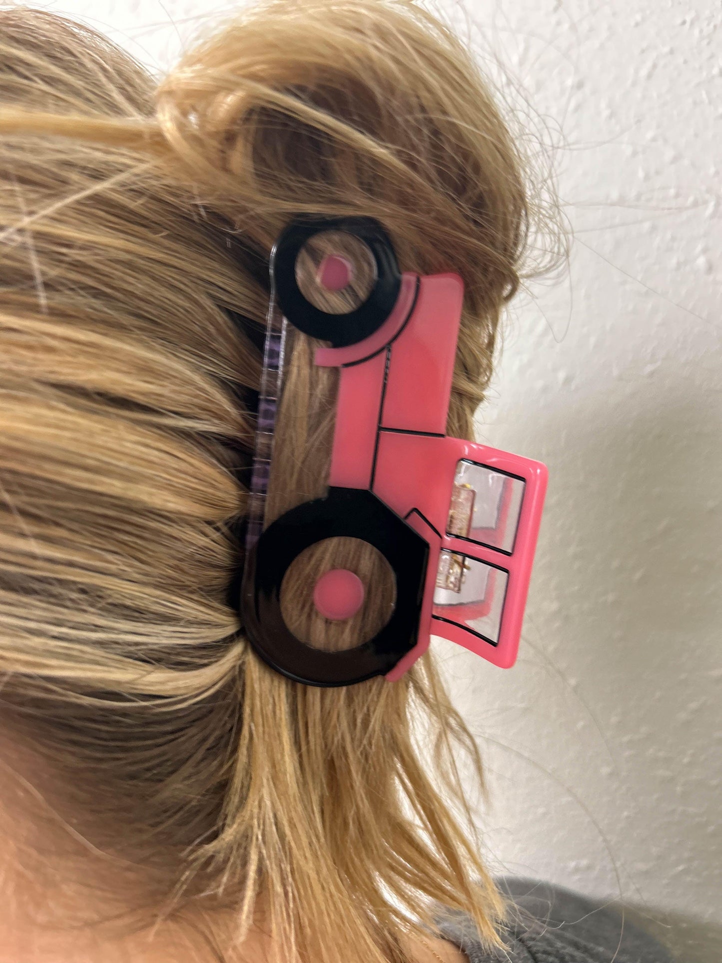 Picture capturing a woman's hair embellished with a Pink Tractor Hair Clip