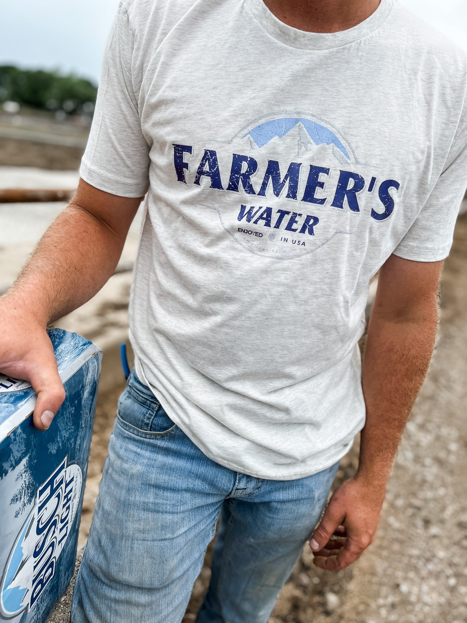 A man wearing Farmers Water Country Tshirt in the field