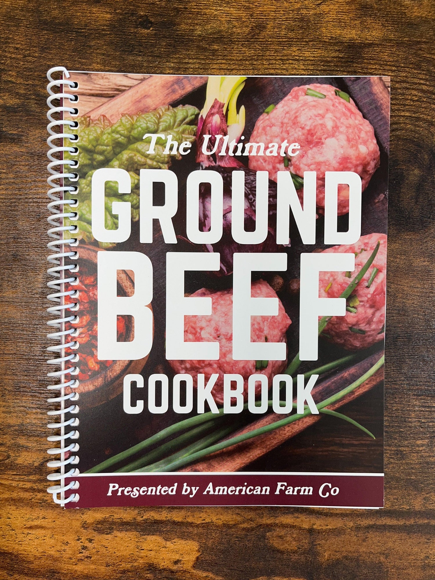 Spiral-bound ground beef cookbook with rustic produce imagery, celebrating American Farm Co's rural heritage and agricultural roots.