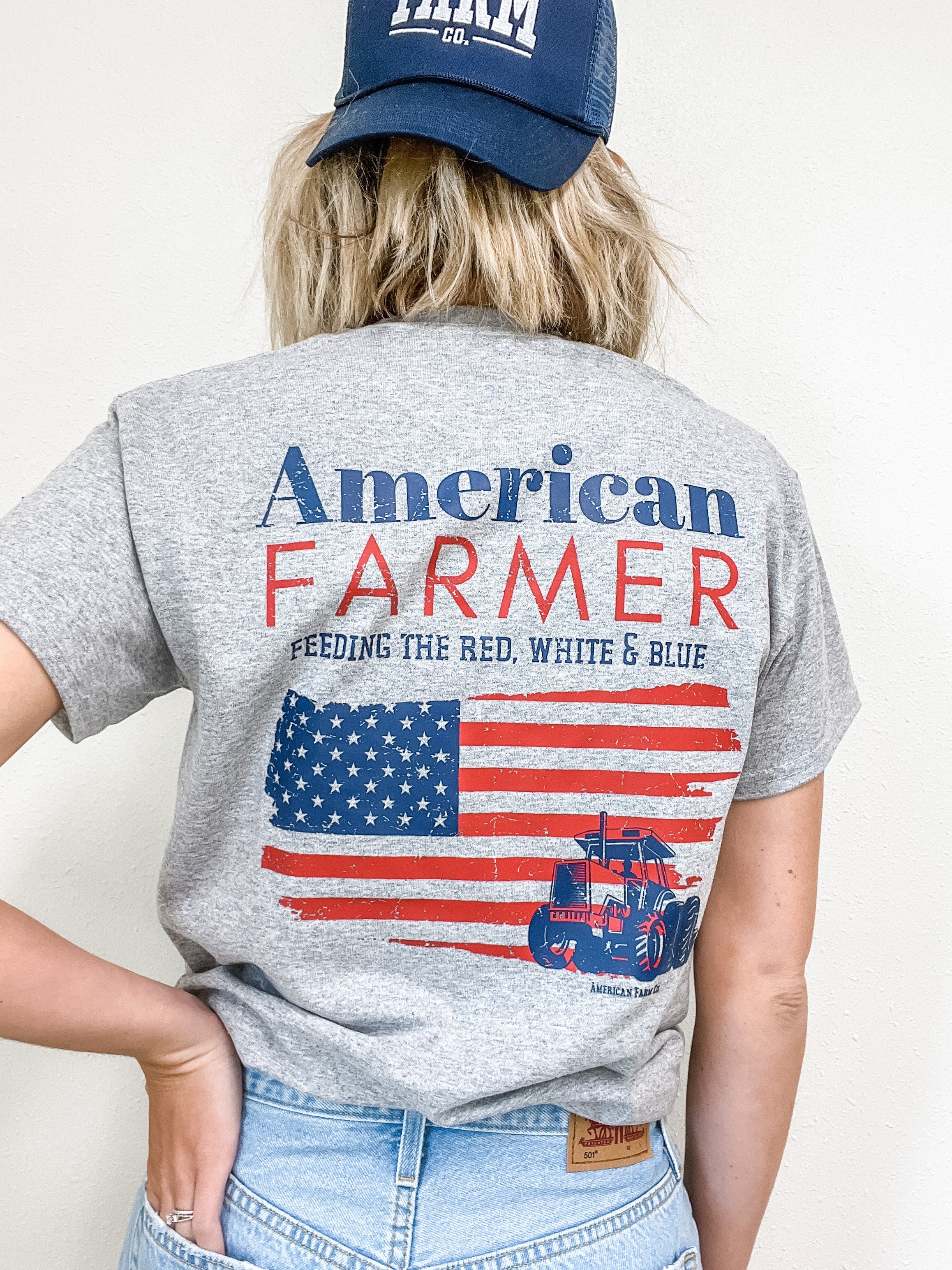 Woman wearing an american farmer tee with backwards blue american farm company