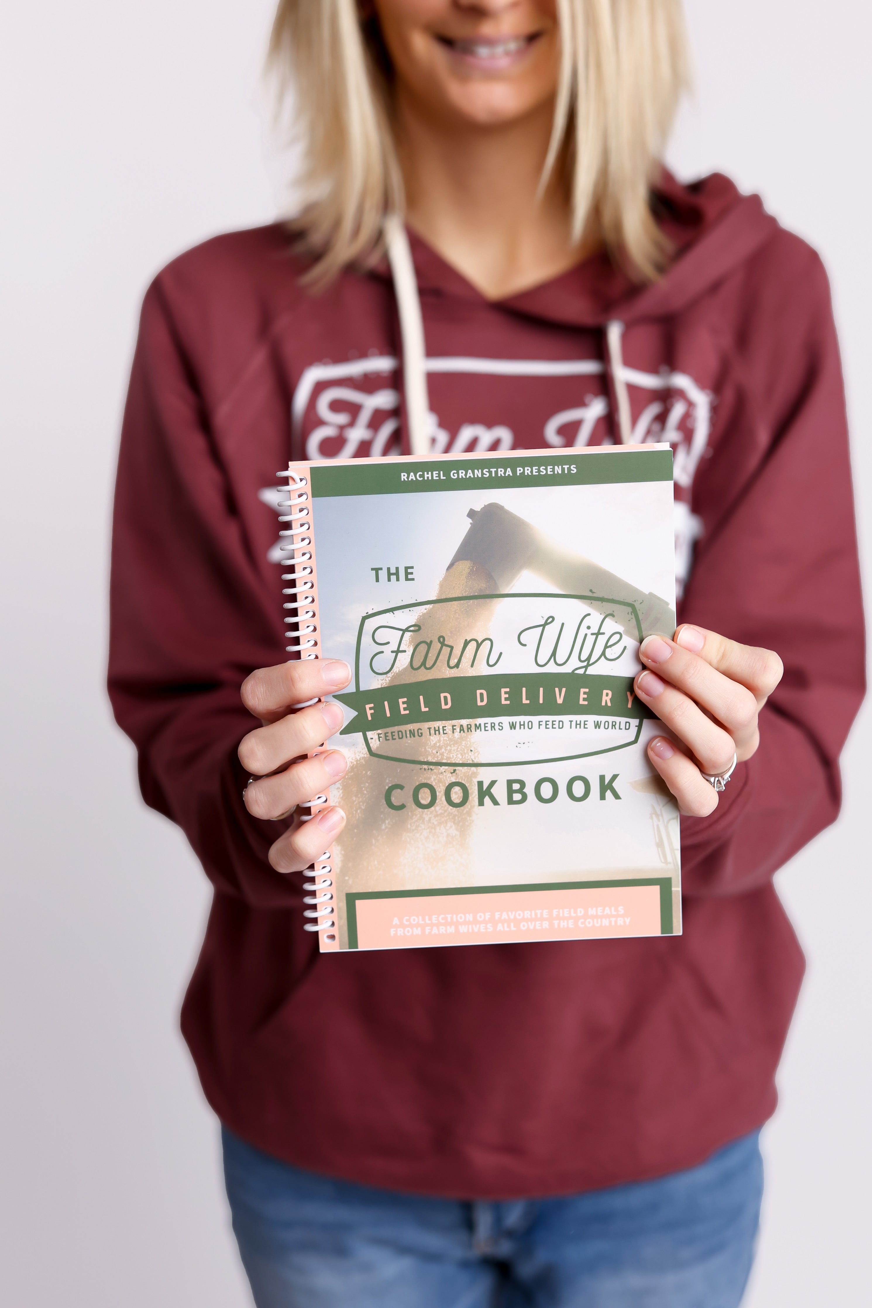 Woman in red hoodie holding the farm wife delivery cookbook