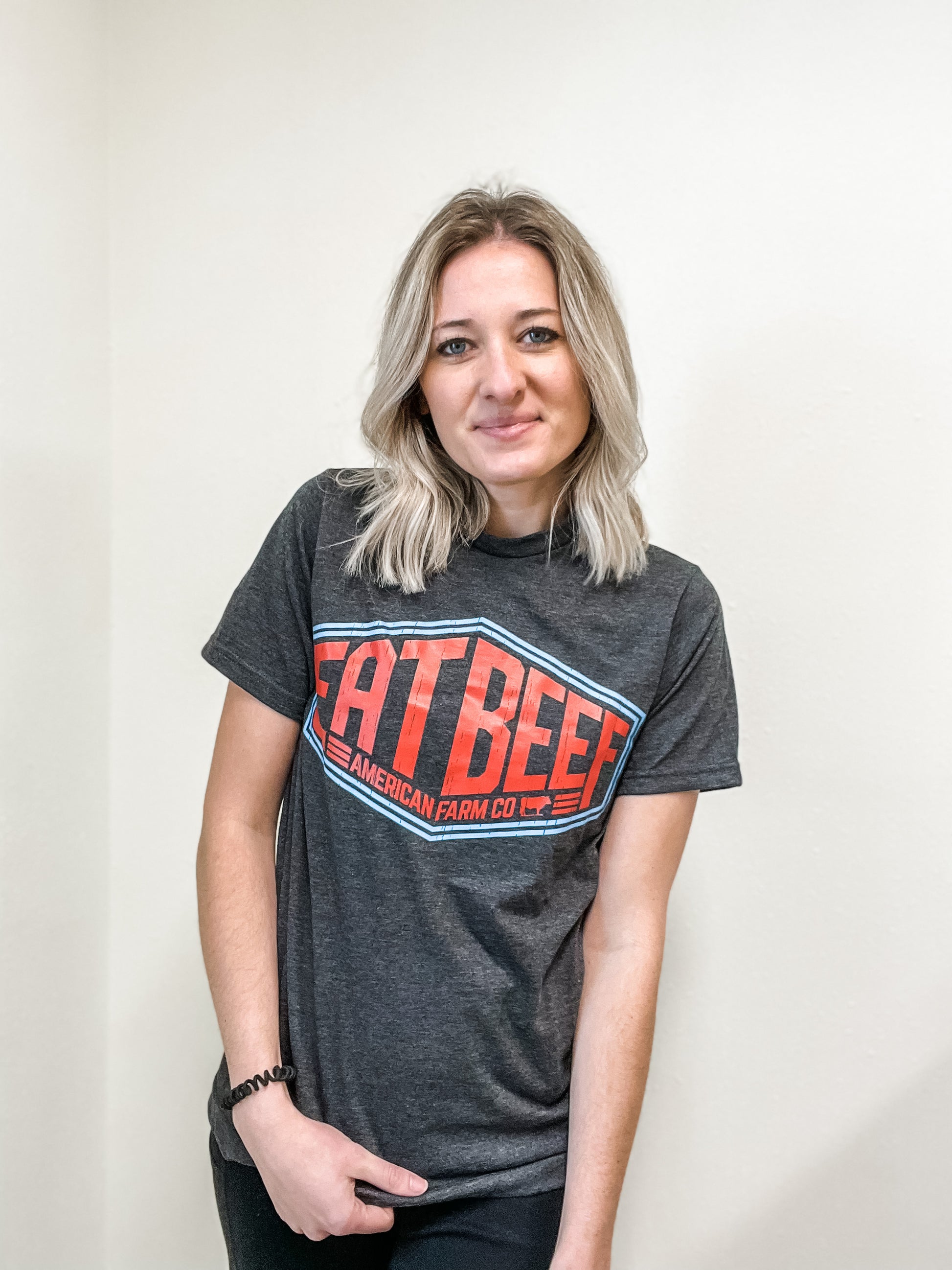 A women wearing a Eat More Beef Sign tshirt against the wall